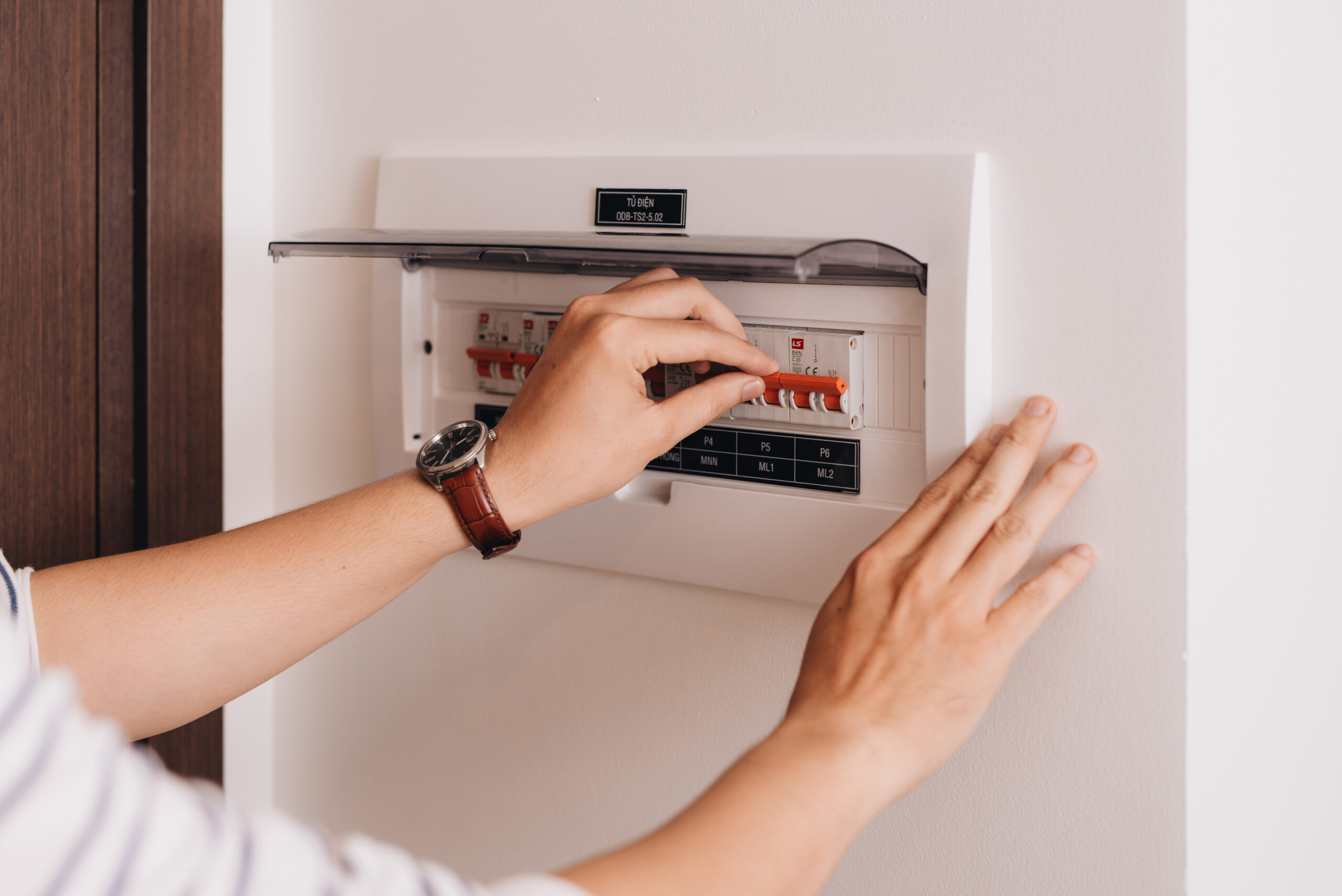 Circuit breaker board displays many switches A finger is about to turn it back on
